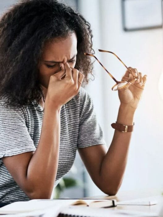 Bir kadın bilgisayar başında çalıştıktan sonra gözlerini ovuşturuyor