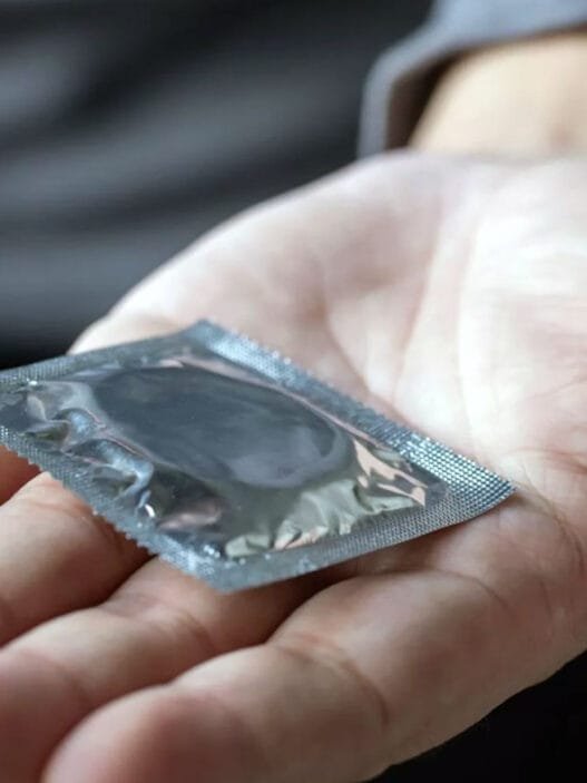 Bir adam prezervatif uzatıyor.